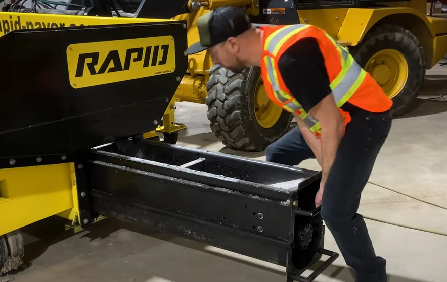 Employee who changes the interchangeable spreading cartridge system of a paver.